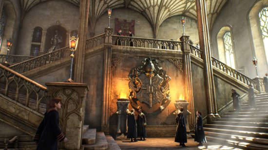 Hogwarts Legacy release date: stairs leading to one of the Hogwarts common rooms.  Students gather in small groups.