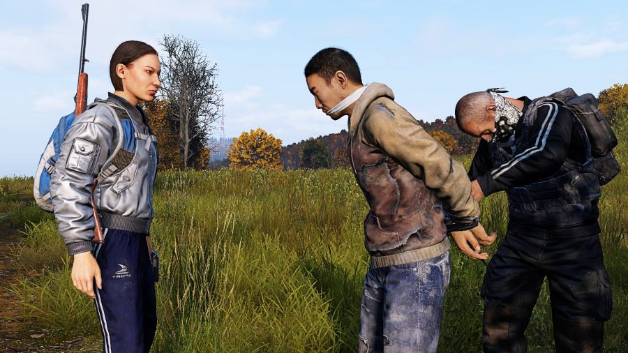 Dayz crossplay: two armed players restrain a third in zombie game DayZ