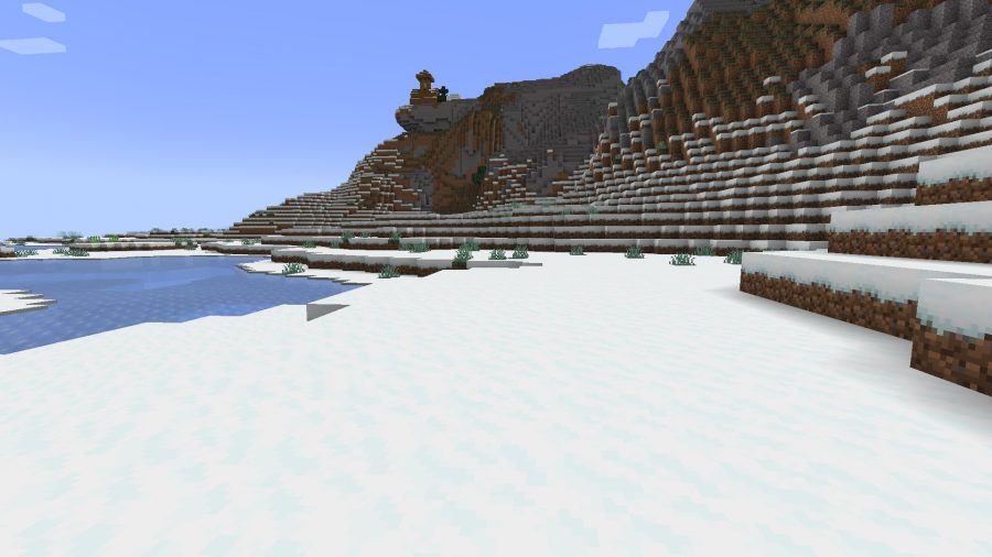 A snowy tundra region with rolling hills and a frozen lake, one of many Minecraft biomes