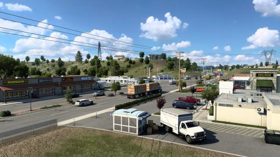 Update 1.44 for American Truck Simulator reworks several California towns, as seen in this sunny picture of a strip mall next to a state highway.