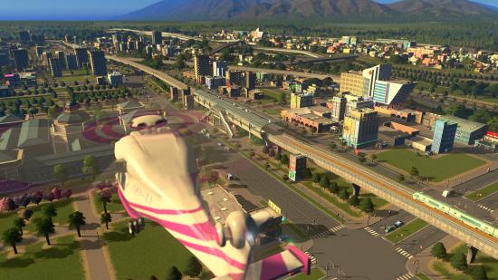 Cities: Skylines is one dollar: a pink-accented helicopter flies above an elevated railway leading to an airport.