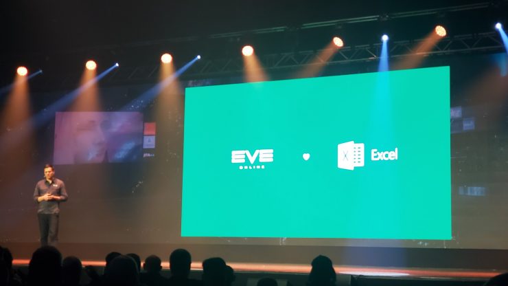 Eve Online creative director Bergur Finnbogasson stands beside a large green slide that reads 'EVE loves Excel'