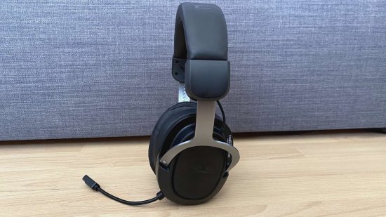The best budget gaming headset - the Asus TUF Gaming H3 - stands upright against a sofa