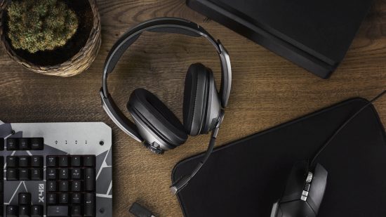 The best wireless gaming headset for travel is the Sennheiser GSP 370, which is lying face down on a wooden table next to a mouse pad