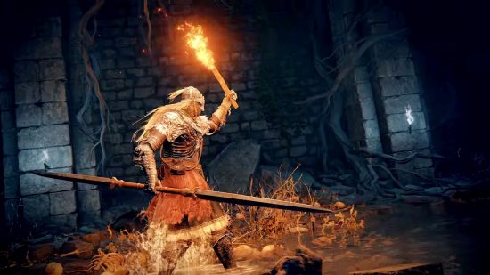 Elden Ring studio's next game in final stages: A warrior armed with a torch and spear explores a dark catacomb in Elden Ring
