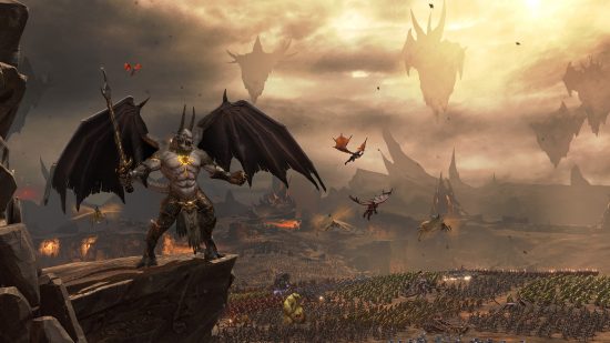 Total Warhammer 3 chaos factions: A daemon prince with horns and huge wings roars as Chaos armies march across the blasted landscape far below