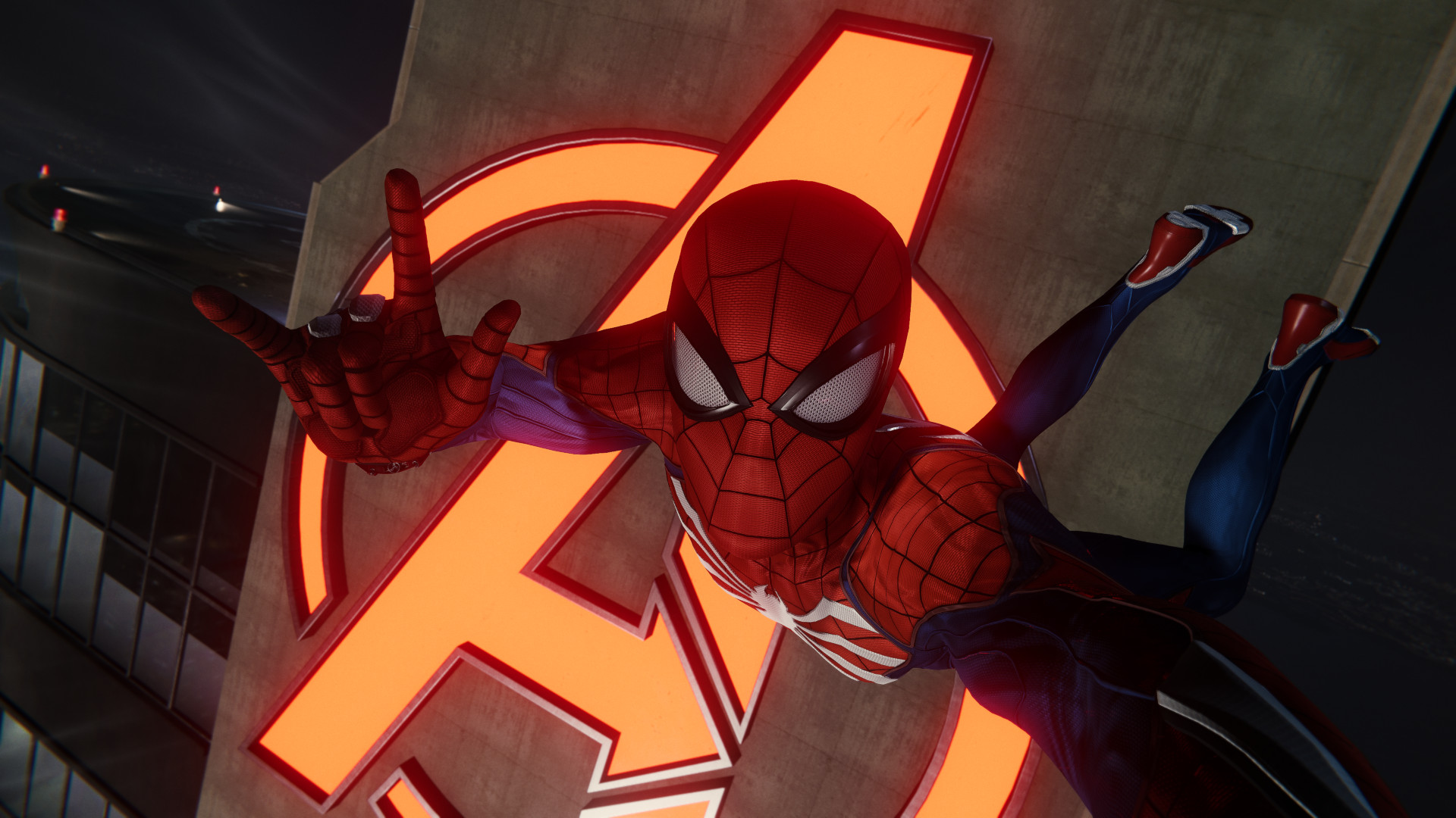 Marvel's Spider-Man Remastered PC review: A selfie of Spidey, giving us the horns with his right hand, against the neon glow of the Avengers Tower