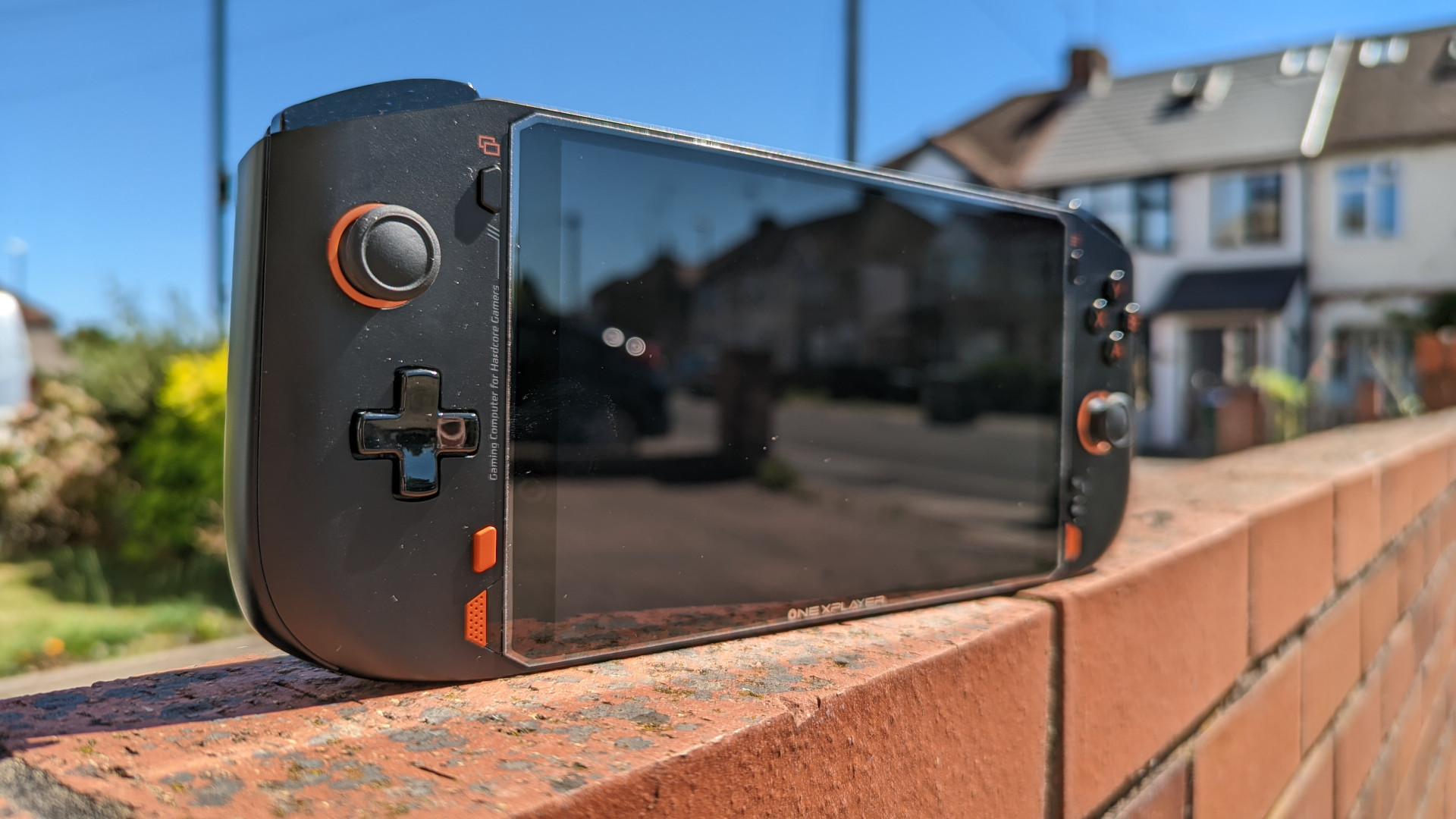 OneXPlayer Mini AMD review: the device sits atop a wall, with the sun beaming down on it