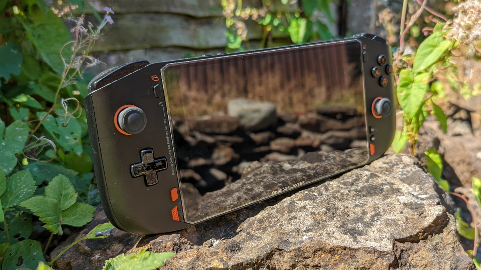 OneXPlayer Mini AMD review: the pocket rocket PC sits atop a rock, surrounded by green flora