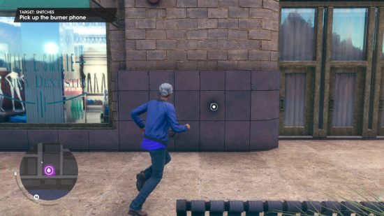 Saints Row guide: the player character is about to pick up a burner phone stuck onto a wall.