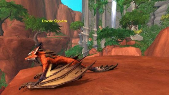 How to tame a Slyvern in WoW Dragonflight: A docile Slyvern perched on the edge of a cliff, surrounded by lush vegetation and a waterfall